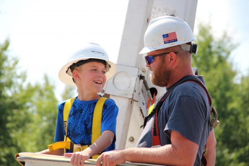 Lineman with boy in bucket truck